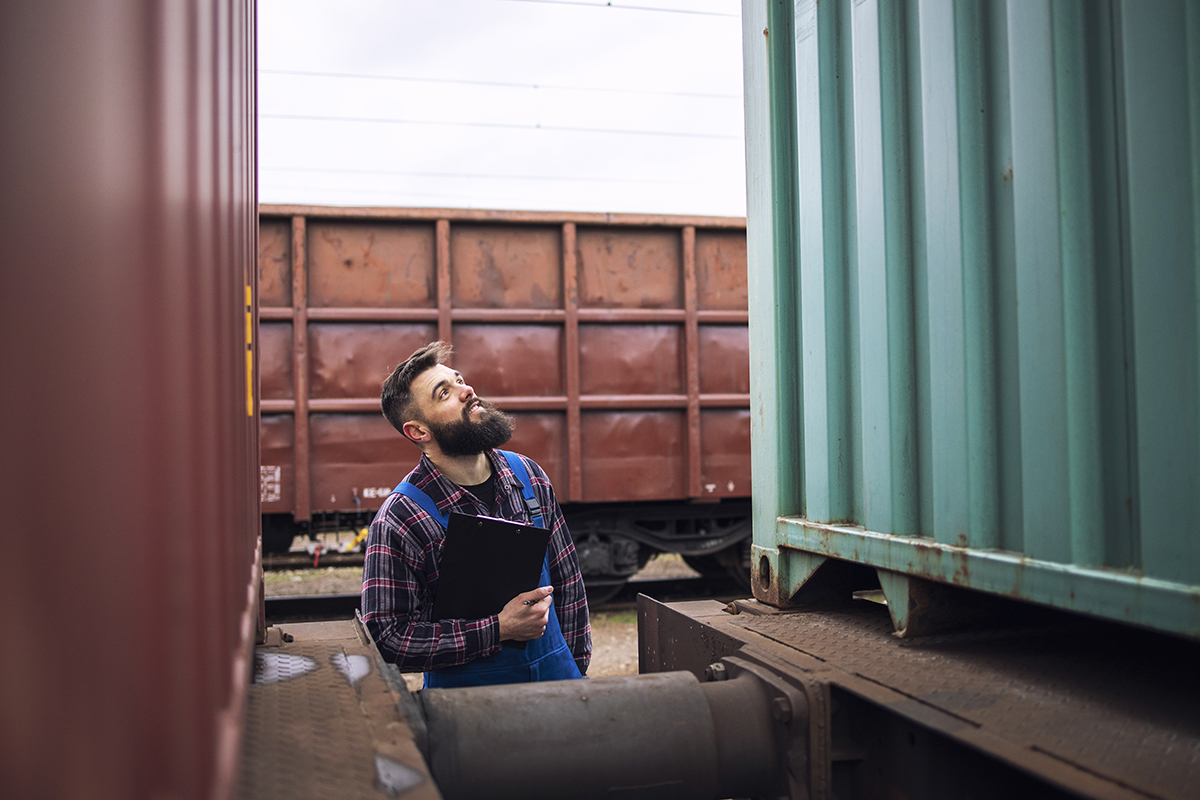 7 Pasos clave para comprar contenedores marítimos de segunda mano: Guía completa 1 supervisor de trabajador ferroviario inspeccionando contenedor de carga de envio en la estacion de tren de carga